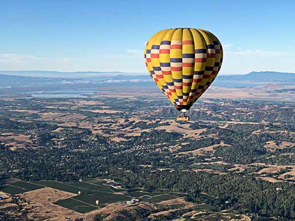 Hot air balloon flying over Napa Valley.